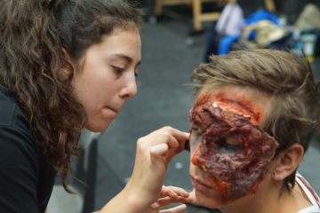 Student applies bloody makeup to create a realistic looking monster.