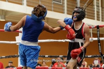 Senior, Kevin Mendoza strikes his opponent in the face during a boxing match.