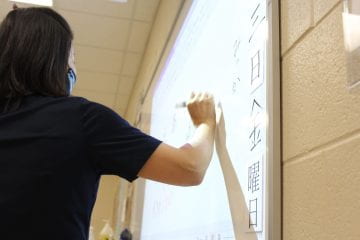 Japanese teacher Dr. Yuka Kato writes Japanese characters for her Japanese II class