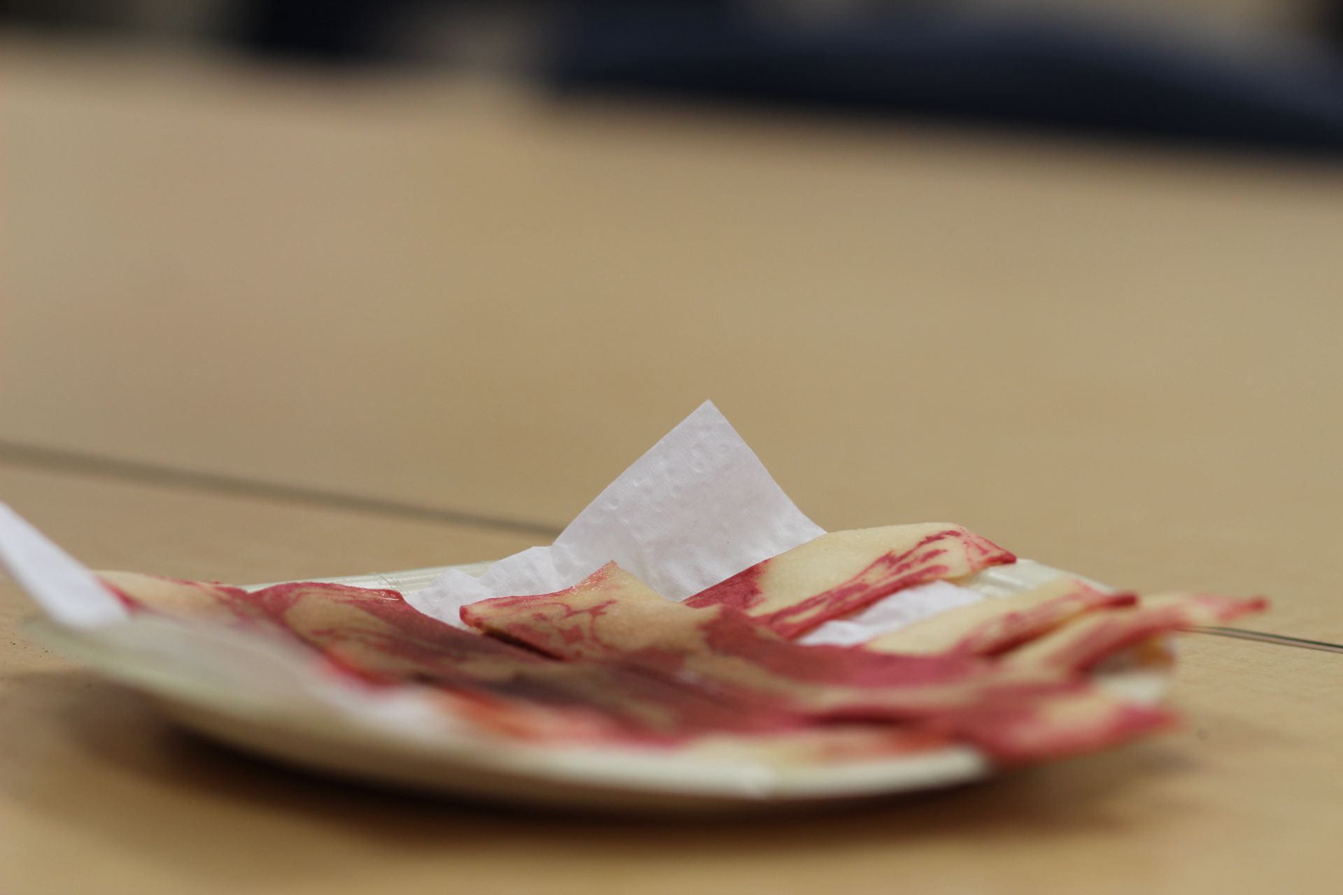 A plate of vegan bacon sits on a plate with a soft, blurred background