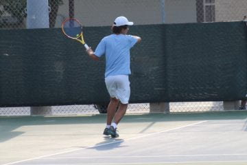 Tennis player is hitting the ball across the court.