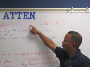 Mr. Bridges is pointing at the word and it seems that his second period class only needs a couple of letters to complete the word.