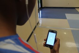 Johnson student opens up the Twitter app in the hall