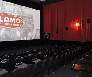 Alamo Drafthouse theater with red walls and large screen that says Alamo Drafthouse