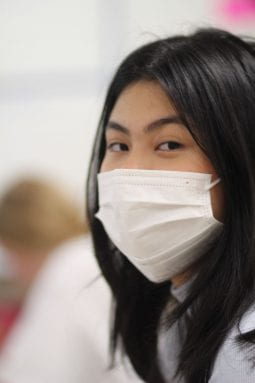 Junior Sidney Uy Tesy faces the camera with a white mask.