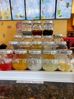 Boba toppings and colorful poppers sit on the front countertop.