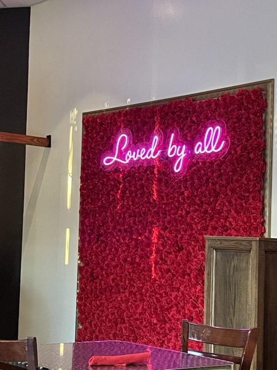 Rose wall that says "loved by all"