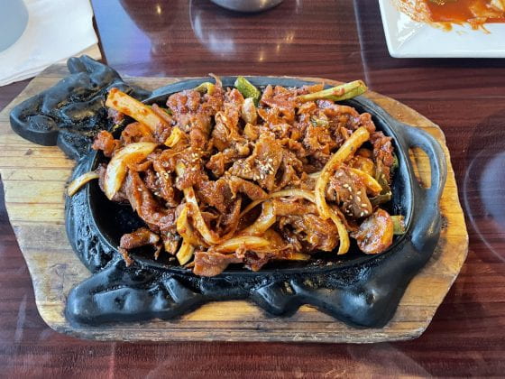 Spicy pork bulgogi on a hot plate shaped like a cow