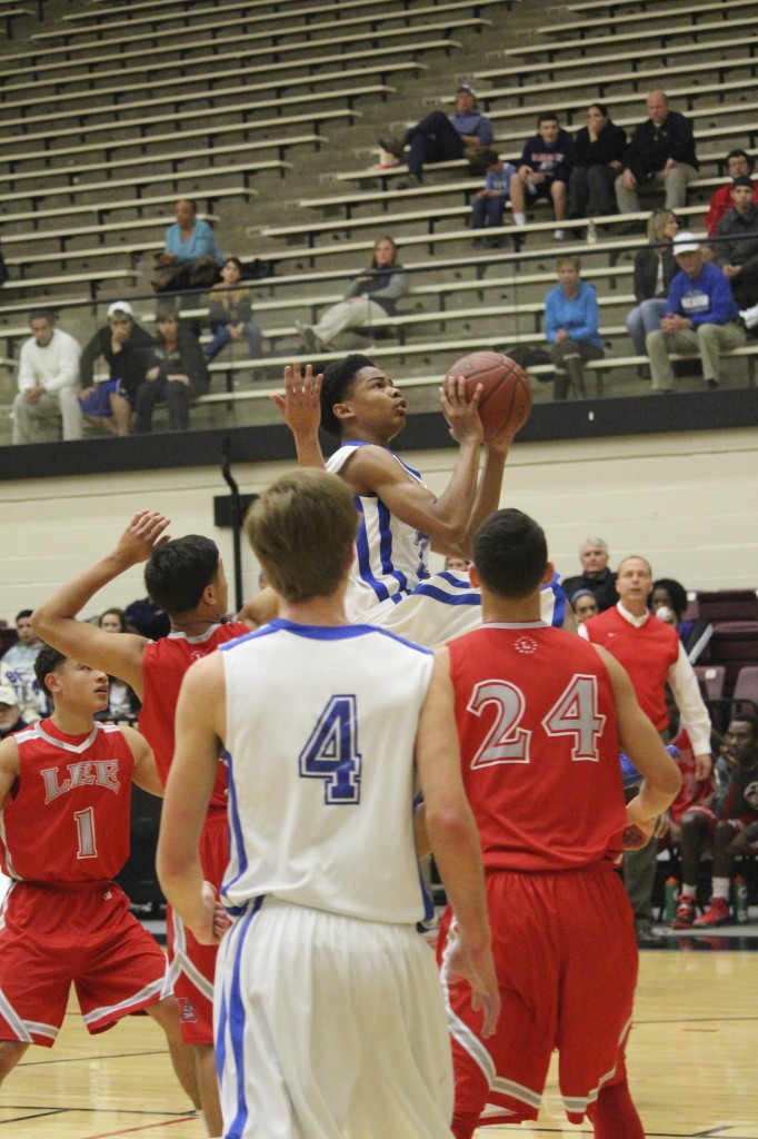 Marcus Harris rises above Lee defenders and dominates on the court. Photo by: Kayla Martin