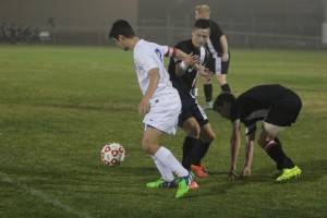 Senior Parker Miller trying to dribble away from two Churchill defenders. Photo by Jacob Dukes
