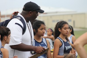 Coach Corey Bedell gives advice to his JV girls runners. 
