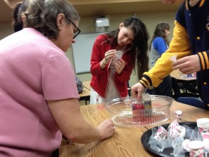 Librarian, Rae Downen helping students make their sand art hearts.