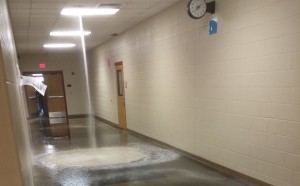 Water pours out of the ceiling in the hall of Rough Rider.