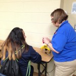 Librarian, Rae Downen helps a C lunch student make her mom a corsage.