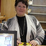 Librarian, Dr. Nancy Hartman behind book checkout desk.